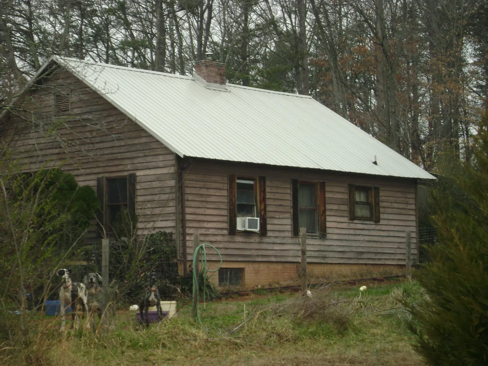White metal roof on an old wood sided farmhouse, from a Metal Roof Installation job in Mesquite